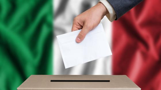 person casting vote in election with Italian flag in background