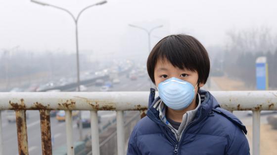 Boy wearing mouth mask against air pollution 