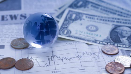 Dollar notes, coins, glass globe and exchange rate chart