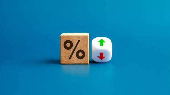 Percentage icon on wooden cube block and up and down arrow symbol on flipping white dice