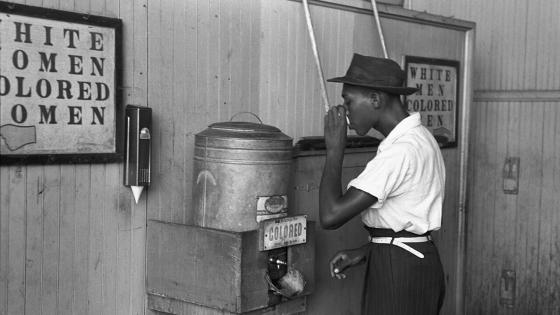 n African-American man drinking at a "colored" drinking fountain in a streetcar terminal in Oklahoma City, Oklahoma, 1939
